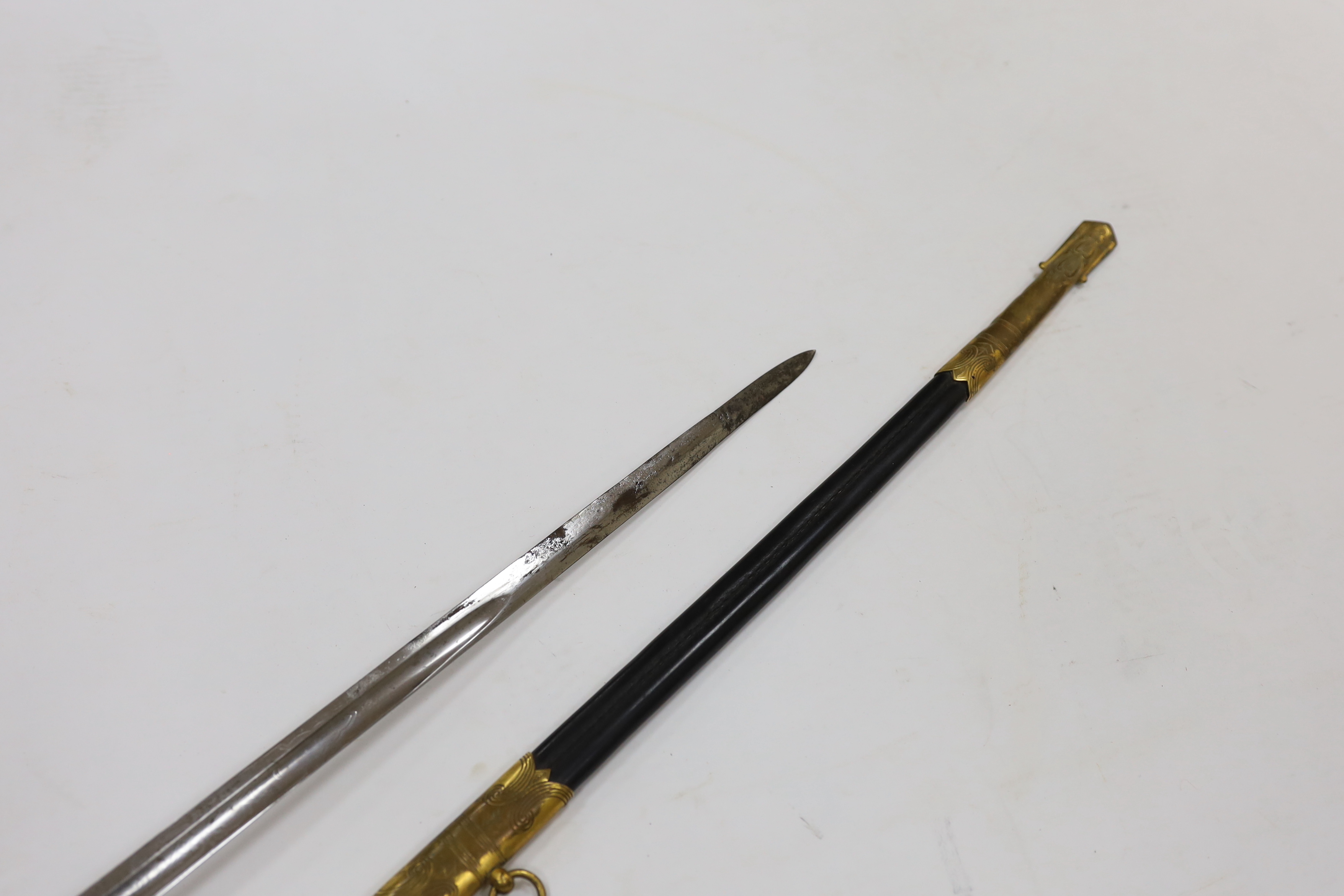 A World War I naval sword with folding guard engraved J.W. Collett R.N., regulation gilt hilt and scabbard mounts, the blade has been refinished and furniture regilded, with bullion dress knot, blade 78.5cm